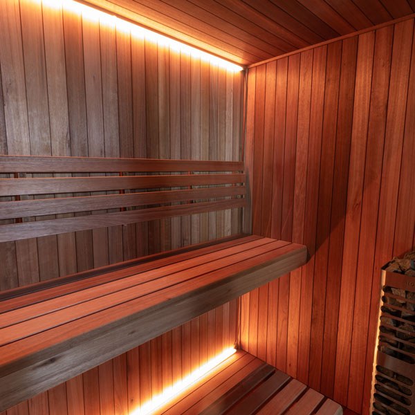 Element Studio indoor sauna with wood benches, optional lighting and partially visible heater (sold separately).