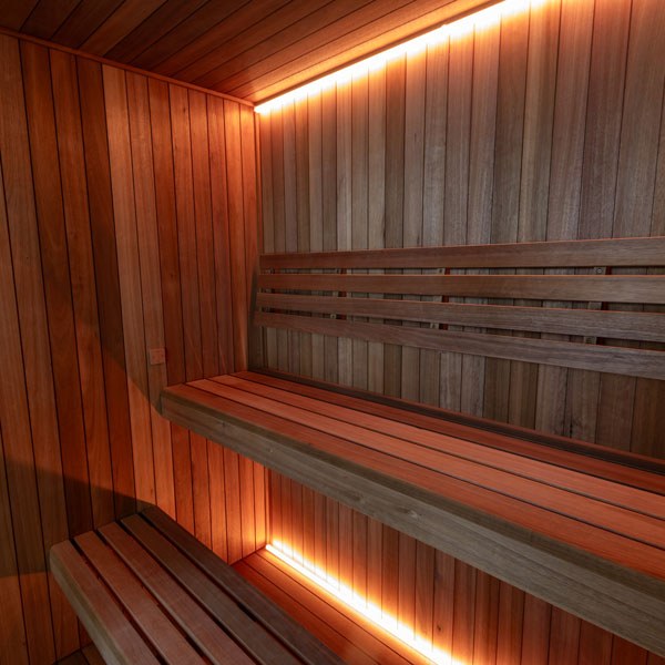 Element Studio indoor sauna interior with upper and lower benches, slatted backrest and optional lighting.